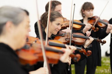 Männer und Frauen in schwarz gekleidet, die Geige Spielen. | © Gasteinertal Tourismus GmbH - Marktl Photography