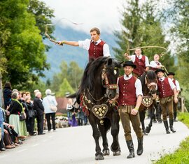 Traditioneller Festumzug mit geschmückten Pferden und Reitern in Tracht, begleitet von Zuschauern. | © SalzburgerLand Tourismus