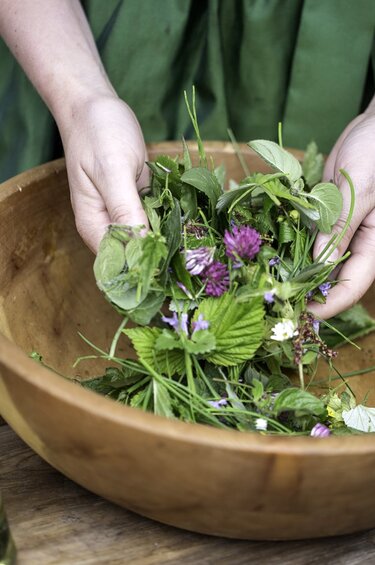 Frau hält verschiedene Blumen in einer Schüssel in der Hand. | © Florian Bachmeier