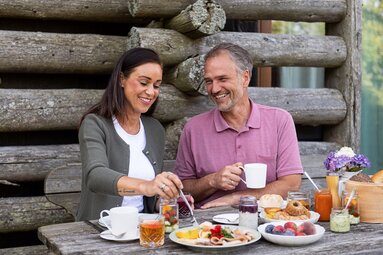 Mann und Frau frühstücken mit regionalen Spezialitäten draußen. | © Ferienregion Nationalpark Hohe Tauern - Carletto Photography