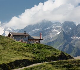 Gletscherblick Alm auf grüner Anhöhe mit Blick auf schroffe, teils schneebedeckte Berge | © Tourismusverband Krimml/Hochkrimml