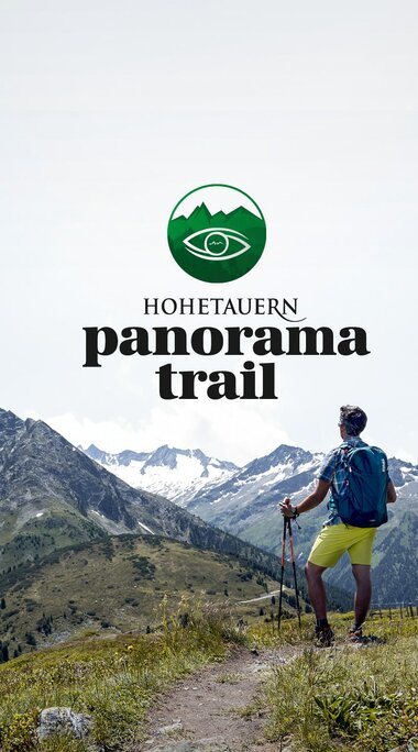 Wanderer auf einem Bergpfad mit "Hohe Tauern Panorama Trail"-Logo vor Bergpanorama. | © Ferienregion Nationalpark Hohe Tauern