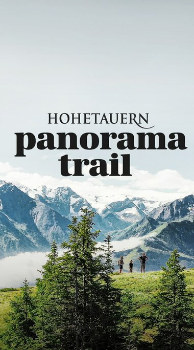Wanderer auf einem grünen Bergrücken mit Blick auf die Hohe Tauern und das Panorama-Trail-Logo. | © Harry Liebmann