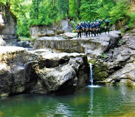 Gruppe von Personen in Neoprenanzügen bei einer Canyoning-Tour an einer felsigen Schlucht. | © FROST Rafting & Canyoning Tours