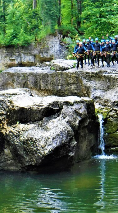 Gruppe von Personen in Neoprenanzügen bei einer Canyoning-Tour an einer felsigen Schlucht. | © FROST Rafting & Canyoning Tours