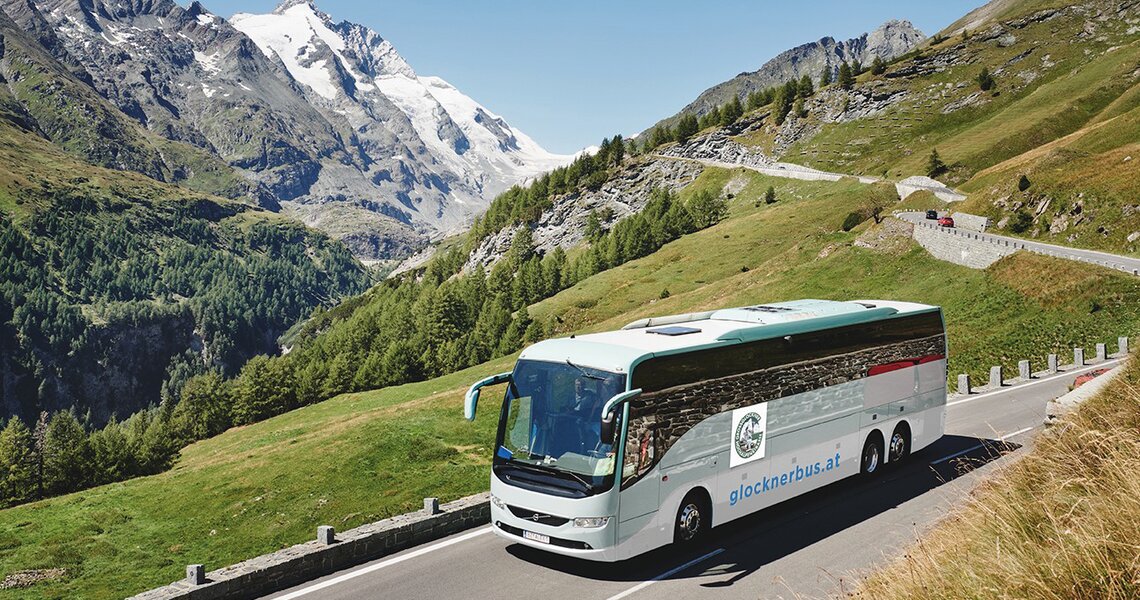 Ein Ausflugsbus fährt entlang der Großglockner Hochalpenstraße mit Blick auf Gletscher und Gipfel. | © Vorderegger Travel - Andrea Stifter Touristik GmbH