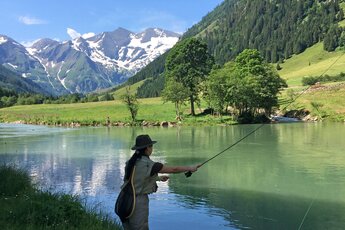 Frau angelt an einem Fluss vor der Kulisse des Großglockners. | © Tourismusverband BRUCK FUSCH | GROSSGLOCKNER