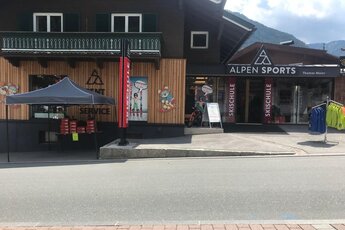 Alpen Sports Shop mit Skischule und Servicebereich vor alpiner Kulisse. | © Alpen Sports