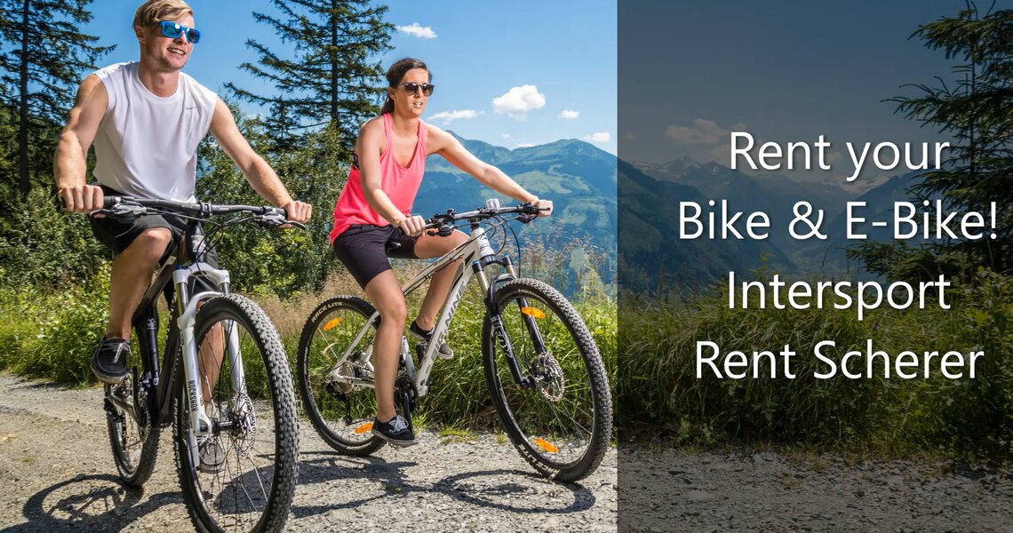 Paar fährt Mountainbikes auf einem sonnigen Weg mit Bergblick. | © Intersport Scherer