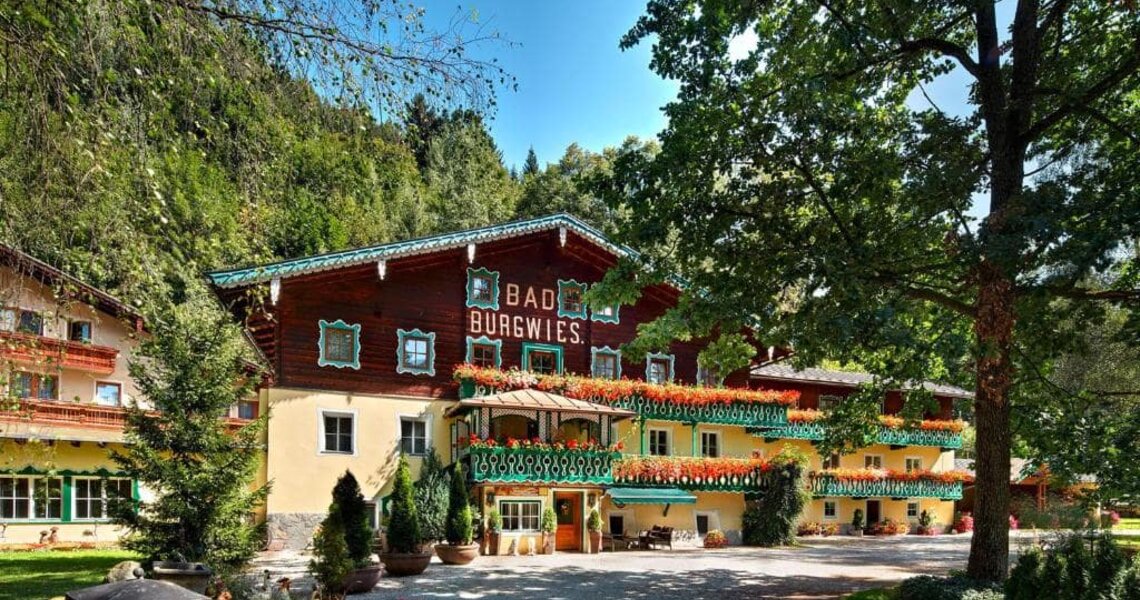 Historisches Gebäude in einer grünen Umgebung mit Blumen und Bäumen. | © Heilbad Burgwies