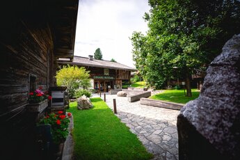 Eingang zum Museum Bramberg mit Holzhaus und Garten im Nationalpark.  | © NPHT - Florian Kreidl-Glück