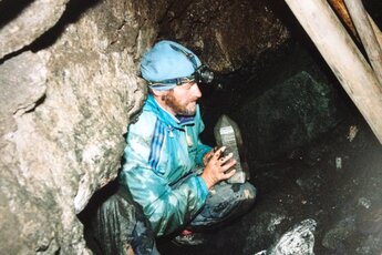 Sammler zeigt einen großen Kristall in einer Mine, umgeben von dunklen Felswänden. | © Mineralienmuseum Wald