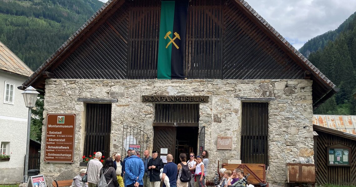 Eingang zum historischen Montanmuseum Altböckstein mit Steinmauern und roten Blumen. | © Montanmuseum Altböckstein