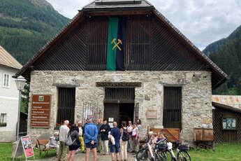 Eingang zum historischen Montanmuseum Altböckstein mit Steinmauern und roten Blumen. | © Montanmuseum Altböckstein
