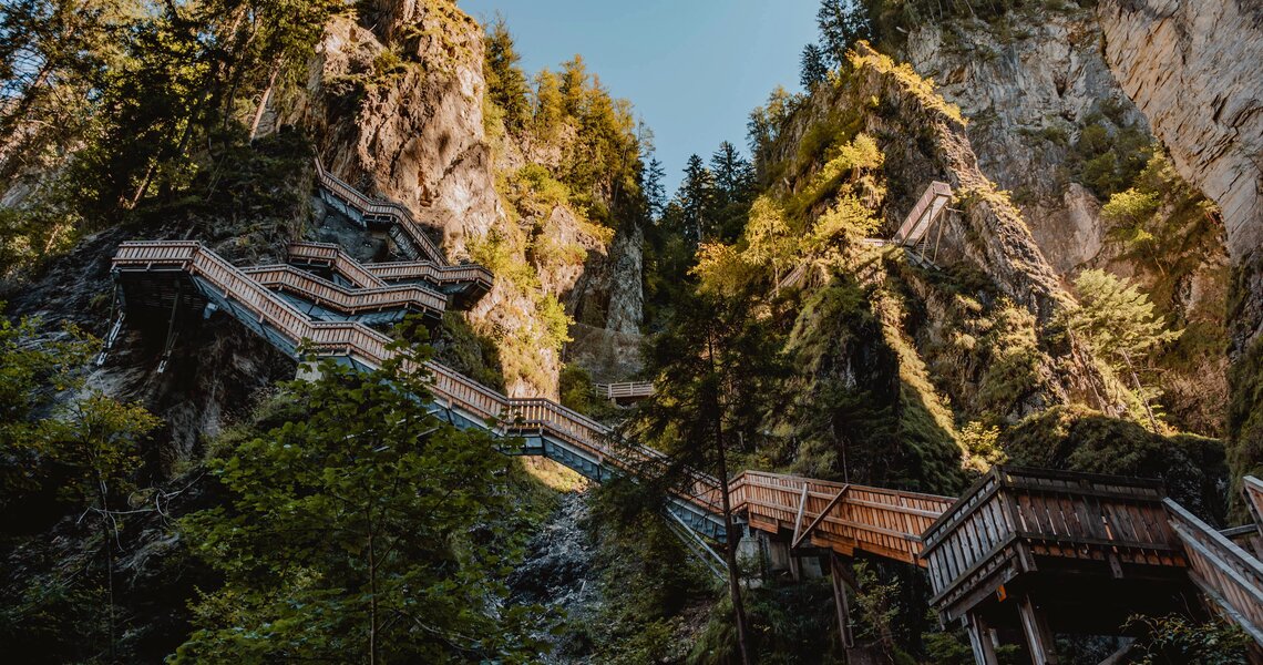 Holzsteg und Treppen in der Kitzlochklamm zwischen steilen Felsen und Wald. | © Karin Pfisterer