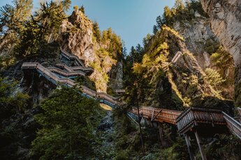 Holzsteg und Treppen in der Kitzlochklamm zwischen steilen Felsen und Wald. | © Karin Pfisterer