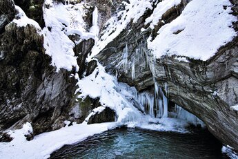 Vereister Wasserfall in einer verschneiten Felslandschaft mit klarem Wasserbecken im Vordergrund. | © Rieder