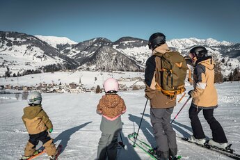 Familie auf Skiern genießt den Ausblick auf Embach im Schnee. | © ©sobietzki
