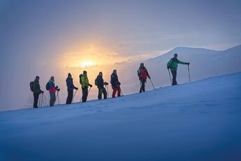 Gruppe beim Schneeschuhwandern im Sonnenuntergang. | © Nationalpark Hohe Tauern - Florian Kreidl Glück