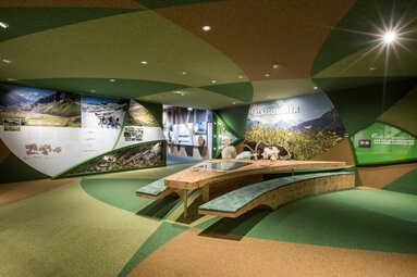 Ausstellung über den Almsommer mit Schafen, interaktivem Tisch und farbenfrohem Design. | © zangl.ultd-Franz Neumayr-Leo
