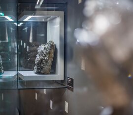Mineral in einer beleuchteten Glasvitrine mit Spiegelungen im Museum. | ©  zangl.ultd-Franz Neumayr-Leo 