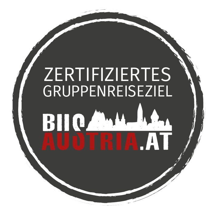 Rundes Logo mit "Zertifiziertes Gruppenreiseziel" und "Bus Austria" in schwarz-weiß-rotem Design. | © Bus-Austria