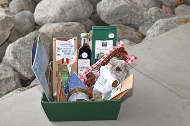 Geschenkkorb mit regionalen Produkten, Honig, Nudeln, Wurst und einem Murmeltier-Plüschtier. | © Nationalparkzentrum Hohe Tauern GmbH
