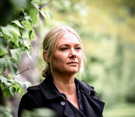 Frau die beim Nationalparkverwaltung Hohe Tauern in Salzburg arbeitet zwischen grünen Blättern. | © NPHT / Kreidl & Glück