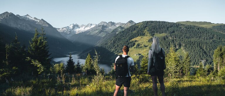 Zwei Wanderer genießen den Blick auf einen Stausee und Gletscher in den Alpen. | © Ferienregion Nationalpark Hohe Tauern - Daniel Kogler