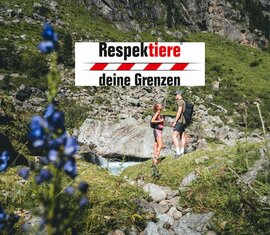 Zwei Wanderer in den Bergen mit dem Slogan „Respektiere deine Grenzen“. | © Daniel Kogler