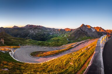 Kurvige Straße mit Blick auf grüne Täler und Berge im Abendlicht. | © van schaik