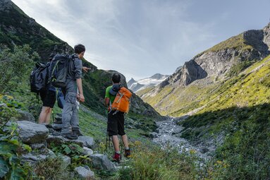 Wanderer zeigen auf einen Gletscher in einer alpinen Berglandschaft. | © Nationalparkverwaltung Salzburg - Kathrin Egger