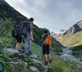 Wanderer zeigen auf einen Gletscher in einer alpinen Berglandschaft. | © Nationalparkverwaltung Salzburg - Kathrin Egger
