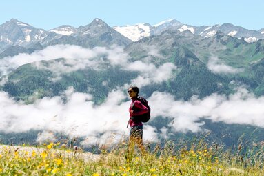 Hiker enjoying the view of majestic Alps and surrounding green valleys. | © Holiday Region National Park Hohe Tauern