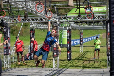 Man swinging through an obstacle course at the Spartan Race. | © Christoph Oberschneider
