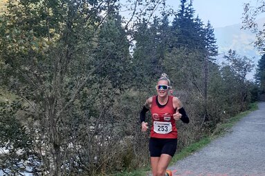 Runner on a forest trail during a race, with autumn trees in the background. | © TVB Krimml