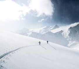 Zwei Skitourengeher im tief verschneiten Hochgebirge. | © Ferienregion Nationalpark Hohe Tauern - Daniel Breuer