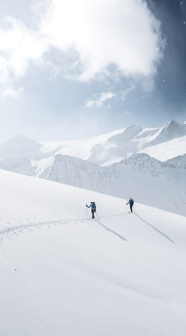 Zwei Skitourengeher im tief verschneiten Hochgebirge. | © Ferienregion Nationalpark Hohe Tauern - Daniel Breuer