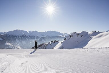 Langläufer auf frisch präparierter Loipe mit Sonne und Alpenpanorama. | © Ferienregion Nationalpark Hohe Tauern - Branislav Rohal