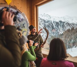 A ranger explains wildlife in winter with antlers in front of a panoramic window. | © SalzburgLand Tourism