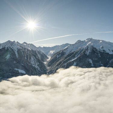 Panorama von verschneiten Bergen über einer dichten Wolkendecke. | © Ferienregion Nationalpark Hohe Tauern - Innerhofer
