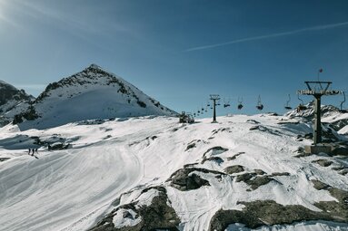  Sessellift über schneebedecktem Skigebiet mit Felsen und Bergkulisse bei Sonnenschein. | © TVB Uttendorf - Klaus Steiner