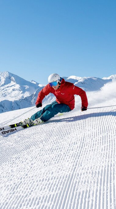 Skifahrer carvt auf frisch präparierter Piste in den Alpen. | © Gasteinertal Tourismus GmbH - Oberschneider