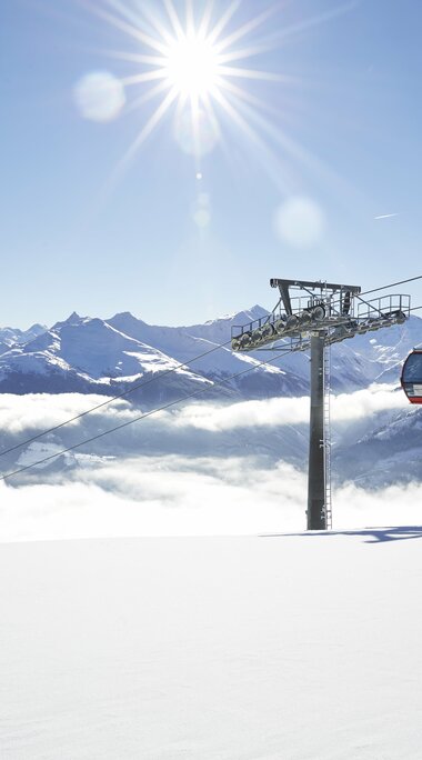 Rote Gondelbahn schwebt über Wolkendecke in den Alpen. | © Mittersill Plus GmbH - Michael Huber
