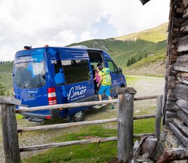 Wanderer steigen aus blauem Shuttlebus in den Bergen | © Ferienregion Nationalpark Hohe Tauern / www.nationalpark.at