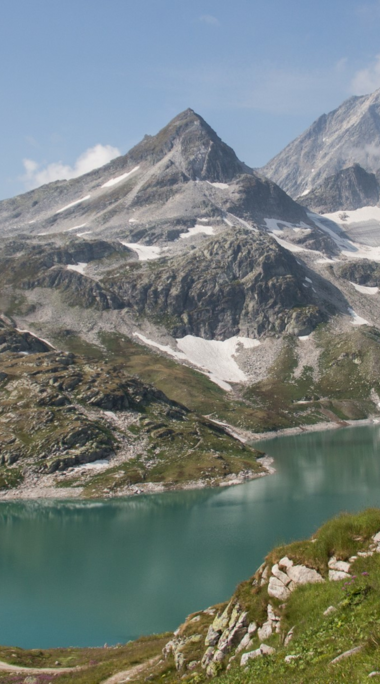 Turquoise mountain lake surrounded by snow-covered peaks. | © Hohe Tauern National Park holiday region / Photographer unknown