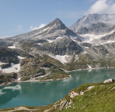 Berglandschaft mit grünem Gletschersee und schneebedeckten Gipfeln. | © Ferienregion Nationalpark Hohe Tauern