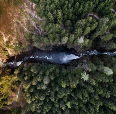  Luftaufnahme eines Wasserfalls, umgeben von dichten Wäldern und Wanderwegen. | © Ferienregion Nationalpark Hohe Tauern