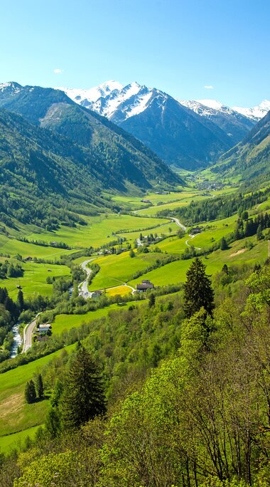 Weitläufiges grünes Tal mit einem Fluss, umgeben von hohen Bergen. | © Tourismusverband Fusch