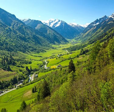 Weitläufiges grünes Tal mit einem Fluss, umgeben von hohen Bergen. | © Tourismusverband Fusch